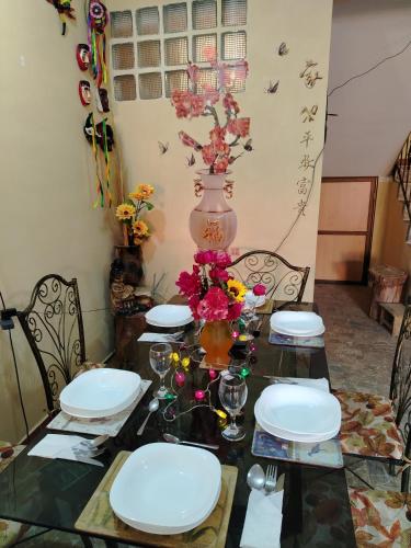 a dining room table with plates and flowers on it at Villa Bella Copacabana in Copacabana