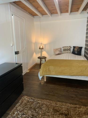 a bedroom with a bed and a dresser with a lamp at Chambres d hôtes H in Lavelanet