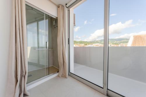 a glass balcony with a view of the city at Casa Rosa Panoramic Seaview in Lagoa