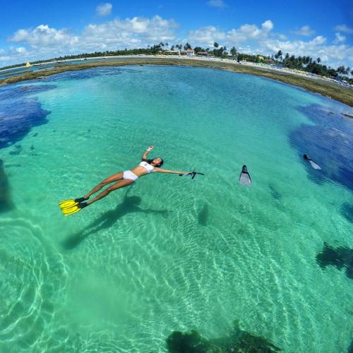 a woman in a bikini swimming in a large body of water at LOFT PREMIUM Boa Viagem 20 andar in Recife