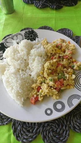 a plate of rice and vegetables on a table at Navi Homestay in Naisisili