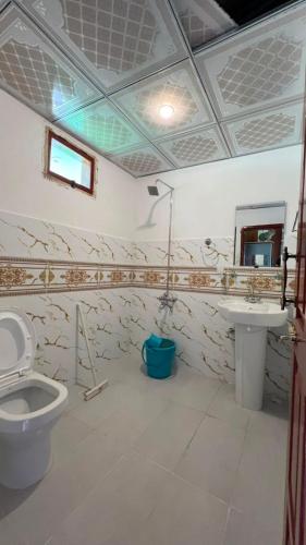 a bathroom with a toilet and a sink at Bagh Rustum Guest House in Holshāl