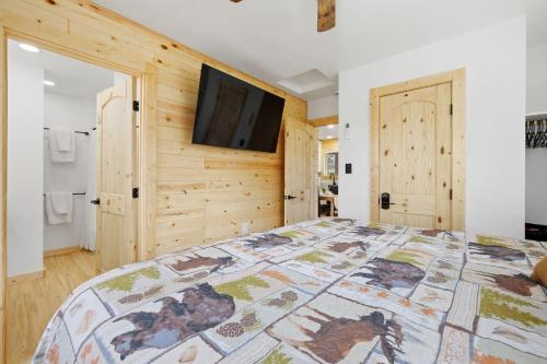 a bedroom with a large bed with a tv on the wall at Custer Love Shack in Custer