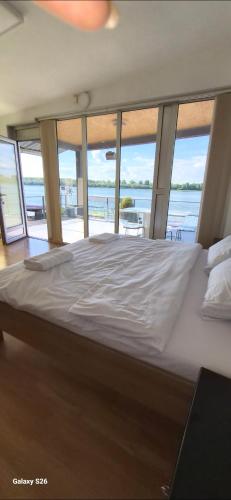 a bedroom with a large bed with a view of the water at Sobe i apartmani "Terasa" in Smederevo