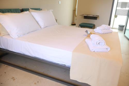 a bed with white sheets and towels on it at Lumiére Marine in Roseto degli Abruzzi