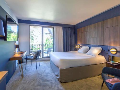 a hotel room with a bed and a balcony at Mercure Marseille Centre Bompard La Corniche in Marseille
