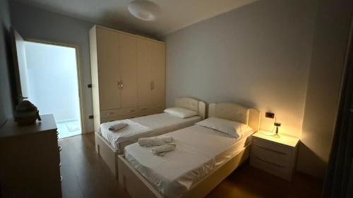 a small bedroom with two beds and a window at REA Apartment in Shkodër