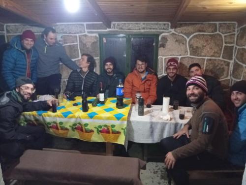 a group of men sitting around a table with a cake at Rinconcito Serrano in Mina Clavero