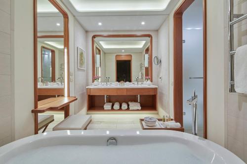 a bathroom with a tub and a large mirror at Regent Porto Montenegro in Tivat