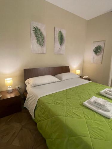 a bedroom with a large bed with a green blanket at La casa al mare in Palermo