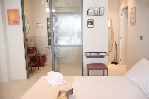 a bedroom with a bed and a glass door to a bathroom at Lumiére Marine in Roseto degli Abruzzi