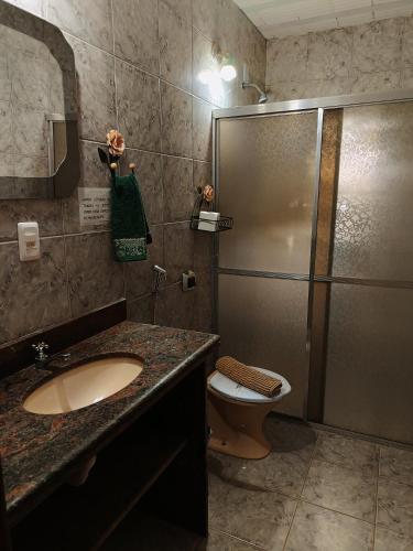 a bathroom with a shower and a sink and a toilet at Pousada Maruru in Serra do Cipo