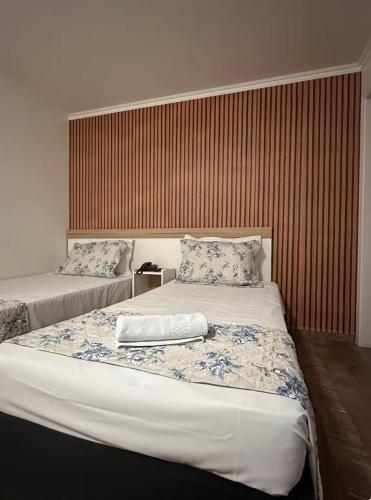 a bedroom with two beds and avertisement at Flat no centro de Curitiba in Curitiba