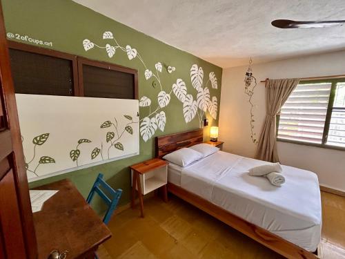 a bedroom with a bed and a wall with flowers on it at Casa Samay in Cozumel