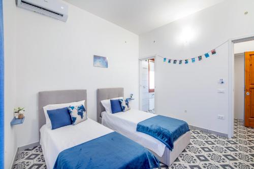 two beds in a room with blue and white at Casa iSuLa in Iglesias