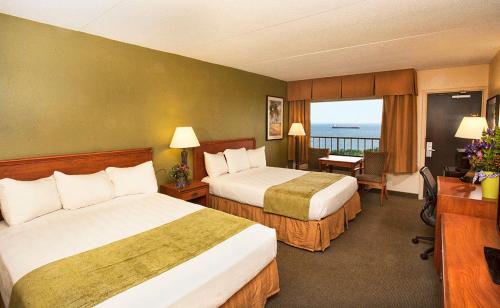 a hotel room with two beds and a balcony at Edgewater Hotel and Waterpark in Duluth