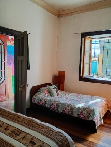 a bedroom with a bed and a window at Hostal Casona del Canto in Los Andes
