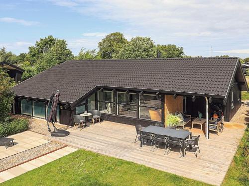 a house with a deck with a table and chairs at 5 star holiday home in Bindslev in Bindslev