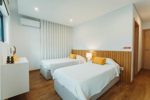 a hotel room with two beds and a television at Casas Peralta - Outeiro in Arouca