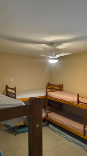 a room with two bunk beds and a ceiling at Linda casa Edícula "fundos do terreno" com piscina in Itanhaém