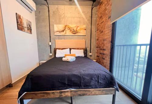 a bedroom with a large bed in a brick wall at depa en el centro con estacionamiento in Monterrey