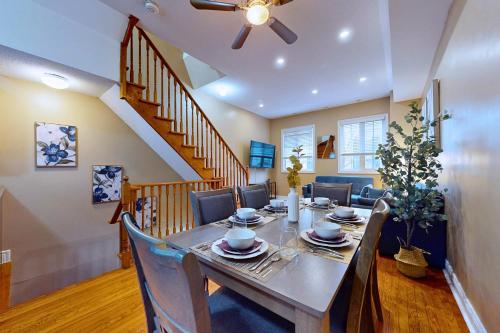a dining room with a table and chairs and a staircase at Private Rooftop Group Suite near Oriole Park - Eglinton Hotel in Toronto