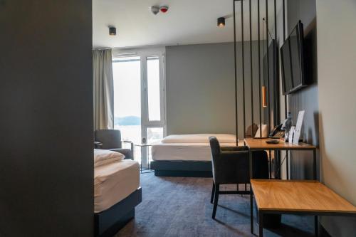 a hotel room with a bed and a desk with a computer at Hotel DEJANIL Hannover Burgdorf in Burgdorf