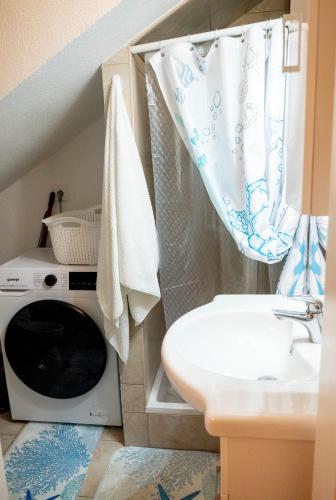 a bathroom with a sink and a washing machine at Villa Aki in Posedarje