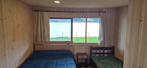 a small room with a bed and a window at Casa primera linea de playa in Maricó
