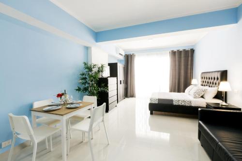 a bedroom with a bed and a table and chairs at SUMMERTIME SUITES - plaza DUKASI - playa LOS CORALES in Punta Cana