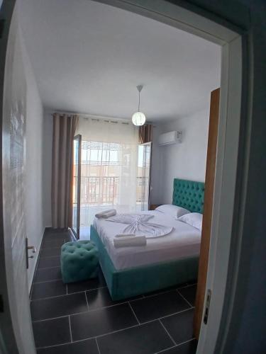 a bedroom with a bed and a large window at Enes apartament in Krujë