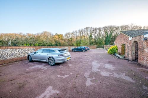 two cars parked in a parking lot next to a brick building at Randall Farm Near Brands Hatch Circuit in Fawkham