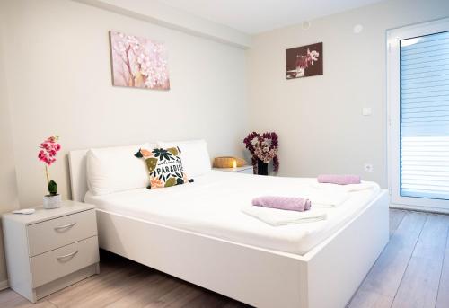 a white bedroom with a large white bed in it at Villa Aki in Posedarje