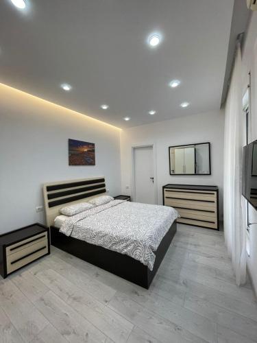 a bedroom with a large bed and a television at Paco Apartment Center Shkoder in Shkodër