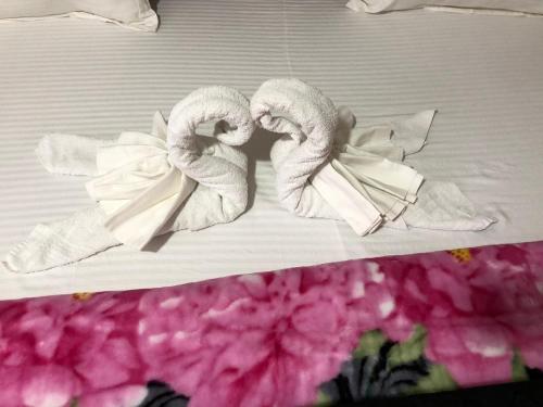 a couple of towels on a bed with flowers at Abronoma Guest House in Ogbojo