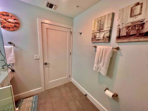 a bathroom with a door and towels on the wall at The Elegant Suite - 2BR with Great Amenities in Paterson