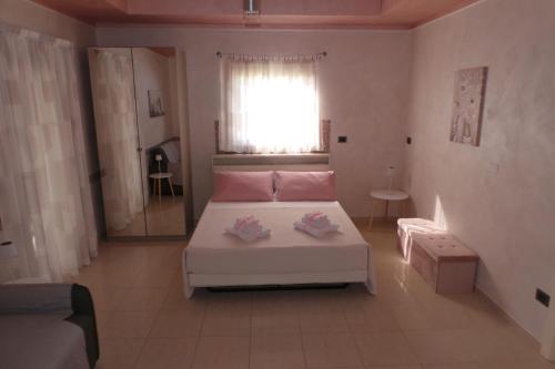 a bedroom with a white bed and a window at La casa di Mazzancollo in San Martino in Pensilis