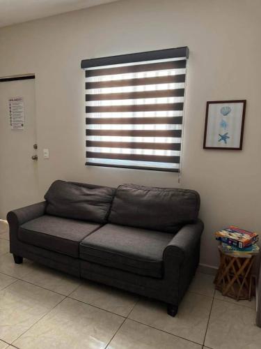 a couch in a living room with a window at Departamento #5 in San Carlos
