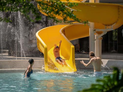 a group of people playing in a water park at Pullman Khao Lak Resort in Khao Lak