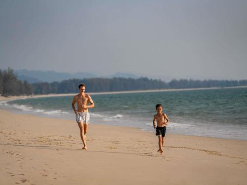 two young men walking on the beach at Pullman Khao Lak Resort in Khao Lak