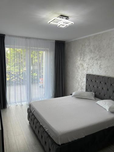 a bedroom with a bed and a large window at Apartament White Tower in Ploieşti