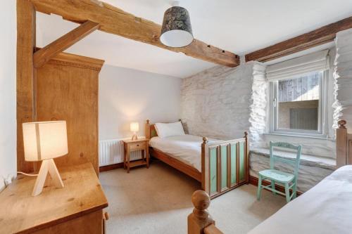a bedroom with a bed and a table and a chair at 2 Bed in Ambleside oc-lr177 in Ambleside