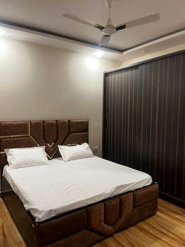 a bedroom with a large bed with a brown headboard at Luxe Farm in Greater Noida