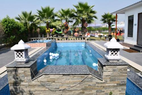 a swimming pool in a yard with a resort at Luxe Farm in Greater Noida