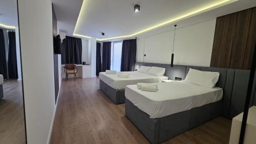 ein Hotelzimmer mit zwei Betten und einem Tisch in der Unterkunft Hotel Velaris in Struga
