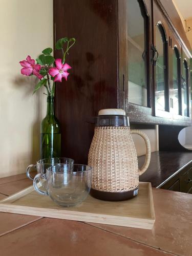 a vase with pink flowers in a bottle on a cutting board at 74YOU Beach Resort and Restaurant in Puerto Princesa City