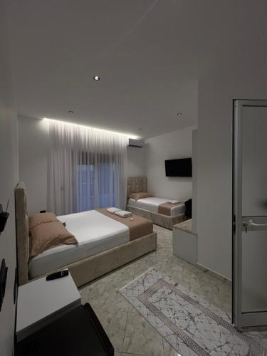 a bedroom with two beds and a television in it at StayVibe in Krujë