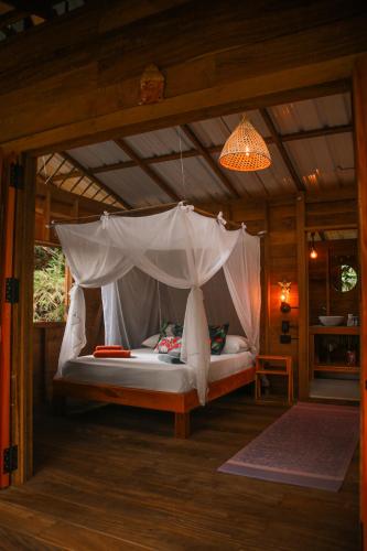 a bed with a canopy in a room at Madre Selva Eco Lodge in Nuquí