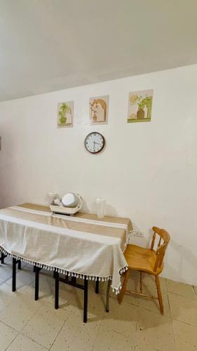 a table and a chair and a clock on a wall at Maru Vibe Guesthouse V2 in San Juan