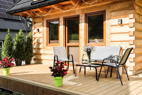 a wooden deck with a table and chairs on it at Domek Za Dworem in Witów